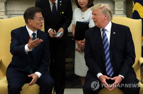 South Korean President Moon Jae-in (L) talks to his U.S. counterpart Donald Trump in a bilateral summit held at the White House on June 30, 2017. (Yonhap)