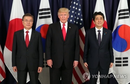 South Korean President Moon Jae-in (L), U.S. President Donald Trump (C) and Japanese Prime Minister Shinzo Abe pose for a photograph before the start of a three-way meeting at the U.S. consulate in Hamburg, Germany on July 6, 2017. (Yonhap)