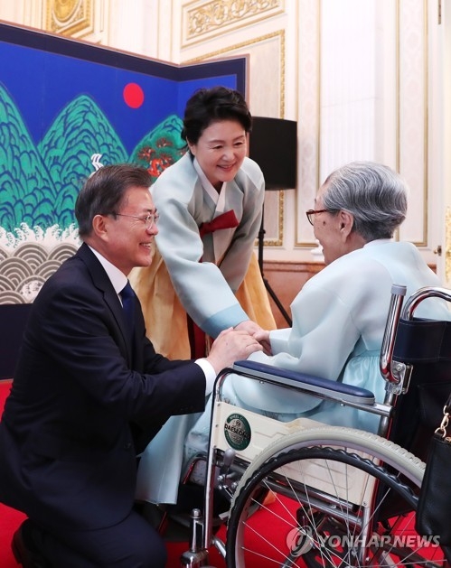In the file photo, taken Aug. 14, 2017, President Moon Jae-in and his wife Kim Jung-sook welcome Kim Bok-dong, a World War II sex slave of the Japanese military, at the presidential office Cheong Wa Dae. The president paid a special visit on Jan. 4, 2018, to the 90-year-old former sex slave, who is currently at a local hospital. (Yonhap)