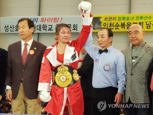 In this file photo taken Nov. 18, 2017, South Korean boxer Choi Hyun-mi (2nd from L) is declared the winner after her World Boxing Association (WBA) women's super featherweight title defense bout in Incheon. (Yonhap)