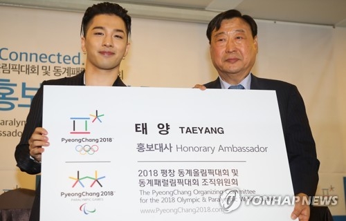 Taeyang (L), a member of boy band BIGBANG, poses with Lee Hee-beom, chairman of the organizing committee for the 2018 PyeongChang Winter Olympics, after receiving a letter of appointment as a promotional ambassador for the sports event at the Press Center in Seoul on June 21, 2017. (Yonhap)