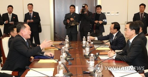 This photo, taken by the Joint Press Corps at Panmunjom on Jan. 9, 2018, shows South Korea's chief delegate Cho Myoung-gyon (R) and his North Korean counterpart Ri Son-gwon during high-level talks between South and North Korea. (Yonhap)