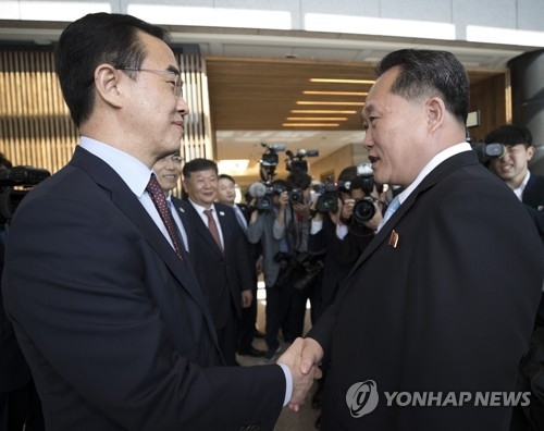 This photo, taken by the Joint Press Corps on June 1, 2018, shows South Korea's chief delegate Cho Myoung-gyon (L) shaking hands with his North Korean counterpart Ri Son-gwon during high-level talks held at the truce village of Panmunjom. (Yonhap)