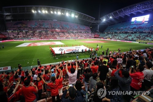 Members of the South Korean men's national football team greet their fans while carrying the national flag at Jeonju World Cup Stadium in Jeonju, 240 kilometers south of Seoul, during a send-off ceremony following a friendly match against Bosnia-Herzegovina on June 1, 2018. It was South Korea's final match at home before the FIFA World Cup in Russia. (Yonhap)