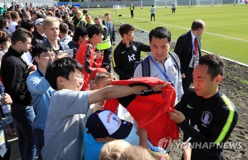 South Korea's Moon Seon-min (R) sign his autograph for fans after training at Spartak Stadium in Lomonosov, a suburb of Saint Petersburg, on June 13, 2018. (Yonhap)