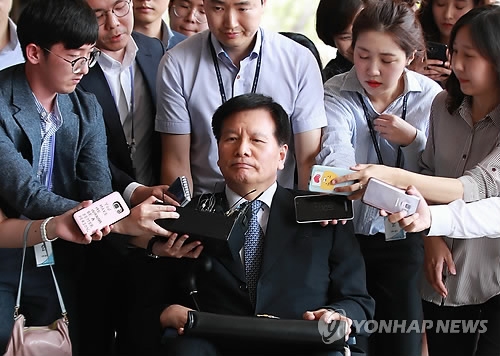 Former Labor Minister Lee Chae-pil is surrounded by reporters as he appeared for questioning at the Seoul Central District Prosecutors' Office on June 25, 2018, over alleged involvement in the spy agency's systematic maneuver to hamper the union activities of two main umbrella labor groups under the former Lee Myung-bak government. (Yonhap)