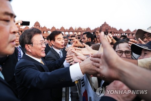 South Korean President Moon Jae-in (2nd from L) shakes hands with Korean residents in India following his visit to the Swaminarayan Akshardham Hindu temple, shortly after his arrival in New Delhi on July 8, 2018, for a four-day state visit. (Yonhap)
