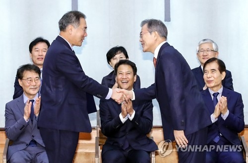 President Moon Jae-in (R, standing) shakes hands with new Minister of Agriculture, Food and Rural Affairs Lee Gae-ho after appointing the latter to the cabinet post in a ceremony held at the presidential office Cheong Wa Dae in Seoul on Aug. 10, 2018. (Yonhap)