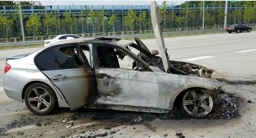 A burned BMW sedan on the side of a road in South Korea (Yonhap)