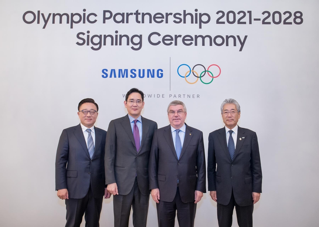 Samsung Electronics President Koh Dong-jin (L), Samsung Electronics Chairman Lee Jae-yong (2nd from L), IOC President Thomas Bach (2nd from R) and IOC Marketing Commission Chair Tsunekazu Takeda pose for a photo after signing Samsung Electronics' sponsorship contract in this photo released by the company on Dec. 4, 2018. (Yonhap)