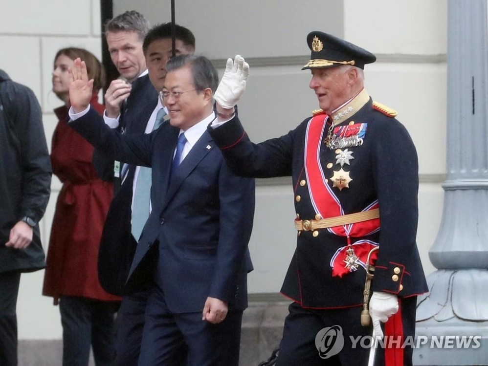 South Korean President Moon Jae-in (L) and King Harald V of Norway wave during an official welcoming ceremony at the royal palace in Oslo on June 12, 2019.