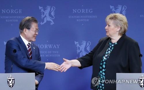 South Korean President Moon Jae-in (L) shakes hands with Norwegian Prime Minister Erna Solberg after a post-summit joint press conference in Oslo on June 13, 2019. (Yonhap)