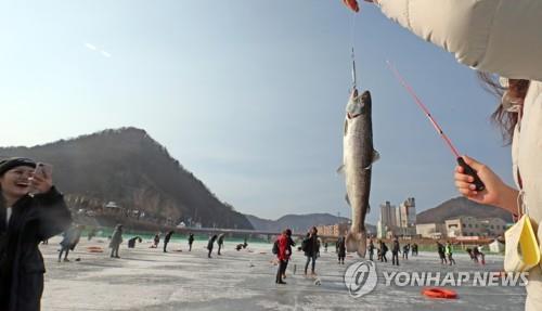 This file photo taken on Jan. 5, 2020, shows foreign tourists enjoying ice fishing in Hwacheon, Gangwon Province. (Yonhap)