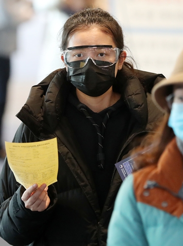 A tourist from the Chinese city of Jinan, Shandong Province, passes through a body temperature checkpoint while wearing a mask and industrial goggles at Incheon International Airport, west of Seoul, on Jan. 29, 2020, amid growing fears over the fast-spreading coronavirus that originated in the Chinese city of Wuhan. (Yonhap)