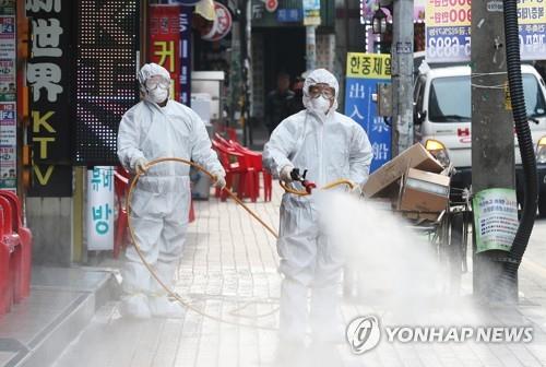Community health service center workers from a ward in Suwon, 40 kilometers south of Seoul, disinfect a street on Feb. 2, 2020 after a person living in the neighborhood was identified as having contracted the novel coronavirus. (Yonhap) 