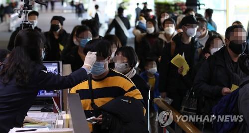 People arriving at Incheon International Airport, west of Seoul, are checked for fever at a quarantine checkpoint on Jan. 28, 2020. (Yonhap)