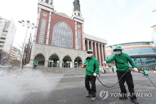 Workers disinfect an area around Myungsung Church, a Presbyterian church with 80,000 followers, in Seoul on Feb. 26, 2020, after a pastor of the church tested positive for the new coronavirus. (Yonhap)