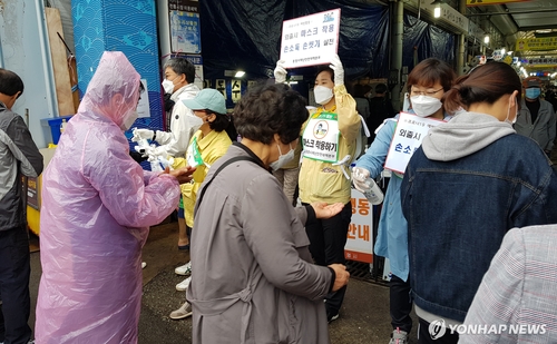 This photo provided by the city of Tongyeong shows local officials and volunteers holding a hand sanitation campaign at a market in the southwestern coastal city on May 3, 2020. (PHOTO NOT FOR SALE) (Yonhap)
