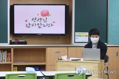 Park Min-young, the homeroom teacher of a sixth-grade class, teaches a teleclass at an empty classroom in Borame Elementary School in Seoul, on May 15, 2020, Teachers' Day, as South Korea has introduced online classes for elementary, middle and high schools during the coronavirus pandemic. On the screen is a message in Korean that says "Mr. Park, Thank You." (Yonhap)