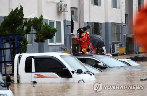 Firefighters rescue residents of an apartment in Daejeon, central South Korea, stranded by heavy downpours and subsequent flooding, on July 30, 2020. (Yonhap)