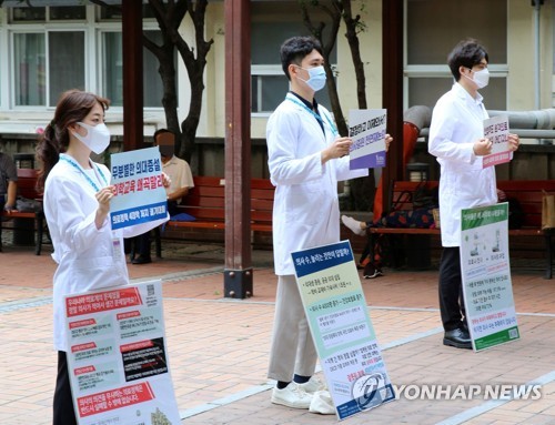 Trainee doctors at Pusan National University Hospital hold up signs denouncing the government's medical reform plan, in downtown Busan, 453 kilometers southeast of Seoul, on Sept. 1, 2020. (Yonhap) 