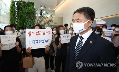 Health and Welfare Minister Park Neunghoo walks past trainee doctors who oppose the agreement reached between the government, parliament and the Korean Medical Association to end the two-week-long strike, in Seoul, on Sept. 4, 2020. (Yonhap) 