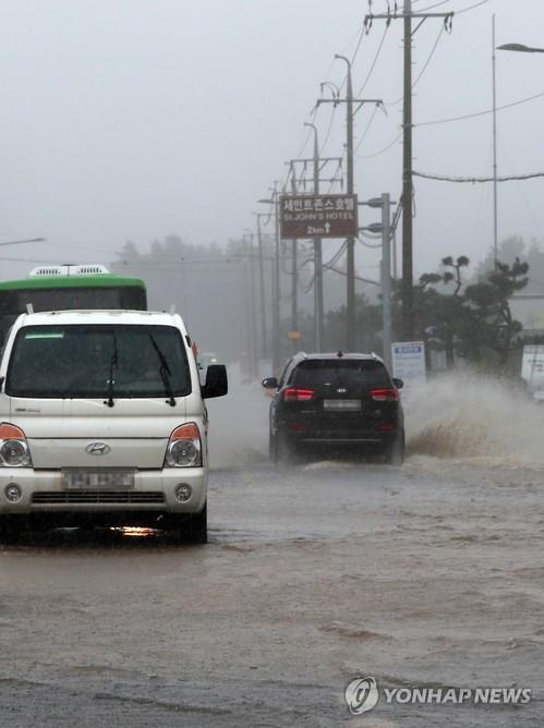 Vehicles drive on a flooded road along the coast of the city of Gangneung on South Korea's east coast on Sept. 7, 2020, in heavy rain caused by the powerful Typhoon Haishen. (Yonhap)