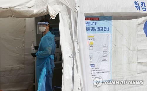 A medical worker gets ready to carry out new coronavirus tests at a makeshift clinic in central Seoul on Sept. 20, 2020. (Yonhap)