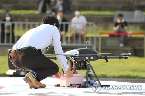 This photo taken on Sept. 19, 2020, shows a person receiving a food box delivery from a drone during a government-led test event in the administrative city of Sejong, some 130 kilometers southeast of Seoul. (Yonhap)