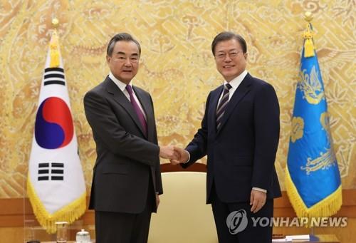 South Korean President Moon Jae-in (R) shakes hands with Chinese Foreign Minister Wang Yi during the latter's courtesy call at the presidential office in Seoul on Nov. 26, 2020. (Yonhap)