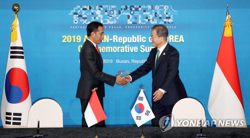 This file photo shows South Korea's President Moon Jae-in (R) shaking hands with Indonesia's President Joko Widodo during their meeting on the sidelines of a special summit between South Korea and the Association of Southeast Asian Nations (ASEAN) in the port city of Busan, 450 kilometers southeast of Seoul, on Nov. 25, 2019. (Yonhap)
