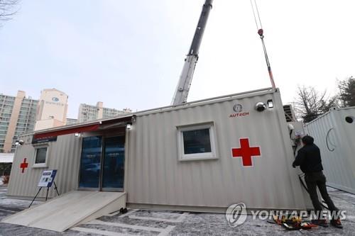 Construction workers build a makeshift ward with shipping containers at a Seoul hospital on Dec. 18, 2020. (Yonhap)