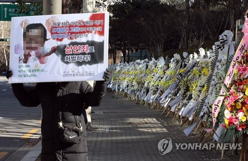 The file photo shows a row of funeral wreaths made of white and yellow flowers laying alongside the wall of the Seoul Southern District Court to mourn the loss of a 16-month-old girl who was allegedly tortured to death by her adoptive parents. (Yonhap)