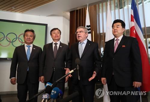 In this file photo from Feb. 15, 2019, International Olympic Committee (IOC) President Thomas Bach (2nd from R) speaks to reporters following a meeting with sports delegations from South Korea and North Korea at the IOC headquarters in Lausanne, Switzerland. Standing with Bach are Lee Kee-heung (L), president of the Korean Sport and Olympic Committee; Do Jong-hwan (2nd from L), South Korean sports minister; and Kim Il-guk, North Korean sports minister. (Yonhap)