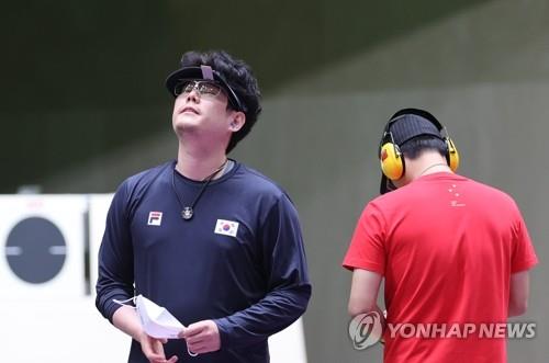 South Korean shooter Han Dae-yoon (L) sighs after finishing fourth in the 25m rapid fire pistol men's final event at the Tokyo Olympics in Asaka Shooting Range in the Japanese capital on Aug. 2, 2021. (Yonhap)