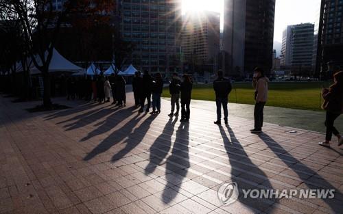 People wait in line to get tested for the coronavirus at a testing center at Seoul Plaza in downtown Seoul on Nov. 25, 2021. (Yonhap)