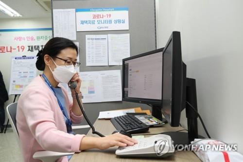 A health care worker talks to a COVID-19 patient who is under at-home care in Seoul on Dec. 2, 2021. (Yonhap)