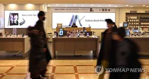 People walk past a Samsung smartphone store in Seoul on Jan. 20, 2022. (Yonhap) 