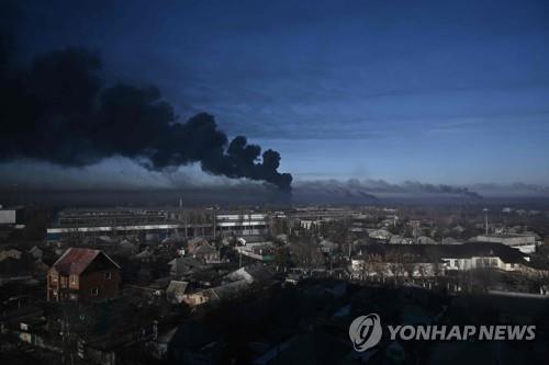 This AFP photo issued on Feb. 24, 2022, shows black smoke rising from a military airport in Chuguyev, near Kharkiv, in Ukraine. (PHOTO NOT FOR SALE) (Yonhap)