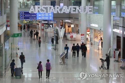 Travelers move about a duty-free zone at Incheon International Airport, west of Seoul, on March 21, 2022, the first day of the abolition of the quarantine for fully vaccinated international travelers. (Yonhap)