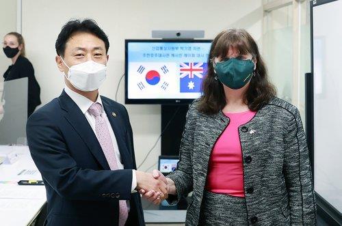This photo, provided by South Korea's industry ministry, shows Seoul's Vice Industry Minister Park Ki-young (L) and Australian Ambassador to South Korea Catherine Raper shaking hands ahead of their talks in Seoul on March 24, 2022. (PHOTO NOT FOR SALE) (Yonhap)