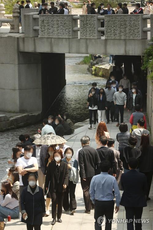 People walk along the Cheonggye Stream in downtown Seoul on April 20, 2022. (Yonhap)