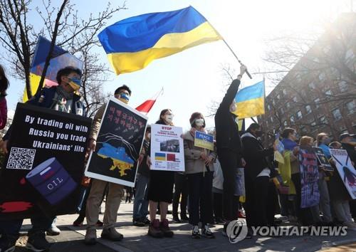 Ukrainians residing in South Korea hold a rally to call on Russia to stop its invasion of their country in front of the Russian Embassy in Seoul on March 27, 2022. (Yonhap)