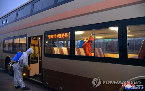 Officials disinfect a bus in Pyongyang amid the coronavirus pandemic, in this undated photo released by the North's official Korean Central News Agency on Feb. 19, 2021. (For Use Only in the Republic of Korea. No Redistribution) (Yonhap)