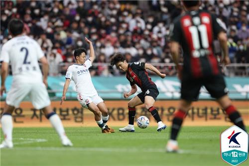 Lee Seung-woo of Suwon FC (L) challenges Hwang In-beom of FC Seoul during the clubs' K League 1 match at Seoul World Cup Stadium in Seoul on May 8, 2022, in this photo provided by the Korea Professional Football League. (PHOTO NOT FOR SALE) (Yonhap)
