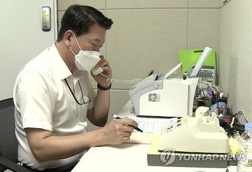 This file photo, provided by the unification ministry, shows a South Korean liaison officer talking to his North Korean counterpart at the Seoul bureau of their joint liaison office on July 27, 2021. (PHOTO NOT FOR SALE) (Yonhap)