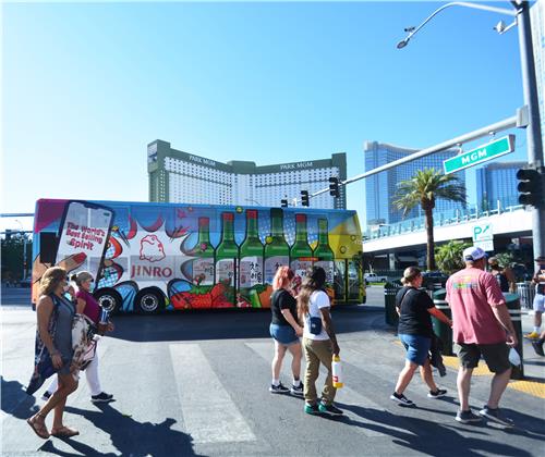 In this undated file photo provided by Hitejinro, local residents and walk past a bus wrapped with the company's Jinro soju product image at a street in Las Vegas. (PHOTO NOT FOR SALE) (Yonhap)