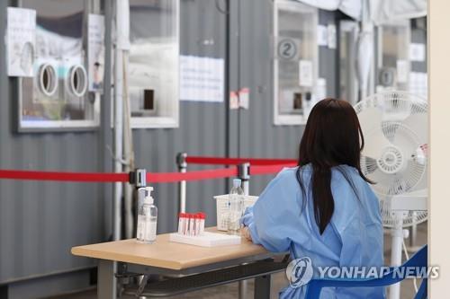 A medical worker sits at a makeshift COVID-19 testing station in Seoul on June 6, 2022. (Yonhap)
