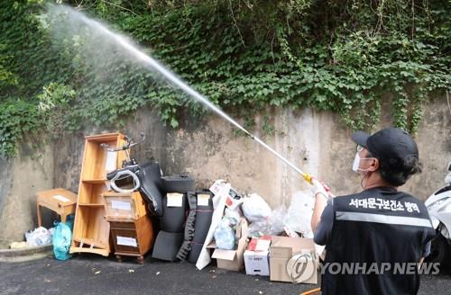 Seoul municipal officials conduct disinfection work against lovebugs in the northwestern ward of Seodaemun on July 4, 2022. (Yonhap)