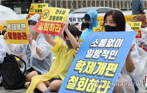 Protesters hold signs during a rally in front of the War Memorial of Korea in Seoul on Aug. 2, 2022, demanding the government scrap its proposal to lower the school entry age. (Yonhap)